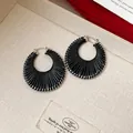 Detailed view of black textured hoop earrings featuring a stylish silver clasp design - Silver Hoop / Small / Black