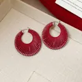 Close-up detail view of red cord-wrapped hoop earrings with elegant silver latches - Silver Hoop / Small / Red