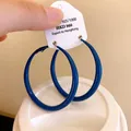 Detailed close-up view of Klein Blue painted round hoop earrings with silver needles on card - Silver Needle - Blue - 50mm Diameter