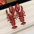 Close-up view of vibrant red textured lacquer lobster earrings displayed in a jewelry tray. - Lobster Style (HE30844) / Burgundy