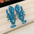 Macro view of vibrant blue lobster statement earrings with a unique textured paint finish. - Lobster Style (HE30844) / Blue