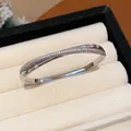 Nahaufnahme eines silberfarbenen Crossover-Armreifs mit schimmerndem Zirkonia-Besatz. - S-Förmiger Kreuz-Stil / 8# Armreif-Silber