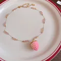Detailed view of a realistic pink resin strawberry pendant on a delicate beaded chain. - Necklace