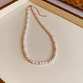 Close-up of elegant pearl necklace with white and pink pearls on cream jewelry tray - Necklace / 6mm Bead Diameter / Pink