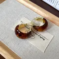Close-up of vintage U-shaped hoop earrings with tortoiseshell resin and gold finish - Gold Brown