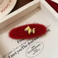 Dettaglio di un fermaglio per capelli in mohair rosso con un charm a cavallo oro. - Clip BB Pony Rosso Ovale
