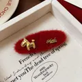 Dettaglio di fermaglio per capelli in feltro rosso con ciondolo a cavallo dorato e scritta - Clip BB Pony Rosso Fatto a Mano