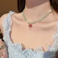 Detailed view of a green beaded necklace with a red mushroom pendant and starfish charm - 26# Necklace - Red Mushroom Pendant Style / Green
