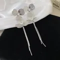 Detailed view of silver leaf tassel earrings with sparkling center stones on velvet - Diamond Petal Tassel Style (Silver Post)