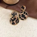 Détail macro de boucles d'oreilles rondes léopard vintage avec bords en métal doré - Petit (14#)