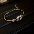 Close-up of elegant gold-toned heart bracelet with sparkling zircon embellishments - Silver