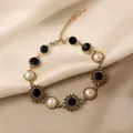 Close-up macro view of vintage gold-toned bracelet with blue gemstones and white pearls - 6 Bracelets - Eco-friendly - Gold