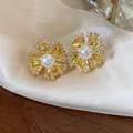 Detail view of gold-plated flower clip-on earrings with pearl center and crystals - Gold Ear Clip Style (Pair)