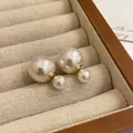 Primer plano de elegantes pendientes de doble perla en una bandeja de terciopelo - 1# Estilo Doble Perla Francés / Blanco