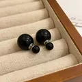 Detailed view of elegant double-sided black bead stud earrings in a jewelry box. - Silver Earring Post-Black