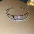 Detailed view of a double-layered silver bracelet featuring a pink zircon bow-knot - Silver-Pink