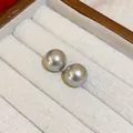 Primer plano de pendientes de perlas redondas grises en un joyero de tela blanca elegante - 36# Pendiente de Perla Gris Plata / 12mm / Gris