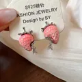 Dettaglio ravvicinato di orecchini a lobo a forma di fragola in resina rosa - Stile con perno dell'orecchino in argento / Rosa Bianco
