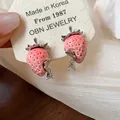 Dettaglio di orecchini a perno a fragola in resina rosa con ago in argento e gocce di zircone. - Stile con perno dell'orecchino in argento / Rosa