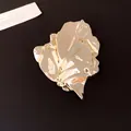 Detailed view of elegant gold metal brooch featuring an irregular wrinkled leaf design - Gold
