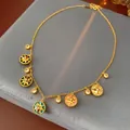 Gold necklace with multi-colored enamel star charms on a grey velvet display. - Style 85# Necklace / Gold-Multicolor