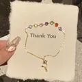Detailansicht eines verstellbaren Goldarmbands mit bunten Zirkonia auf einer Dankeskarte - Rundes Regenbogen Zirkonia Schiebe-Armband / Gold-Mehrfarbig
