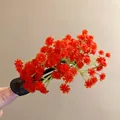 Vue détaillée d'une pince à cheveux à fleurs rouges vives avec une base noire mat - Pince à Bec Florale Rouge