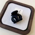 Close-up detail of a matte black wave hair claw clip displayed on a minimalist wooden tray - Hair Claw-Black-Small