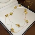 Gros plan des pépites d'or froissées sur un collier à double rangée de style vintage - Collier Double Épaisseur Plissé Irrégulier / Or