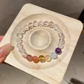 High-quality detail of clear quartz bracelet featuring tiger eye beads on a wooden tray - Style 7 / White