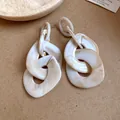 Detailed close-up of oversized geometric acrylic chain link earrings with cream marble texture - Marble White