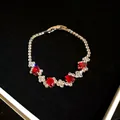 Close-up of a silver-tone bracelet featuring brilliant red oval stones and clear zircons - Red Oval Zirconia / Silver