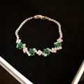 Detailed macro shot of an elegant irregular bracelet featuring green oval zirconia gemstones - Green Oval Zirconia / Silver