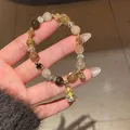 Macro view of phantom quartz and tiger eye bracelet with golden hollow flower spacers - Style 41 (Auspicious Beast Pixiu) / Gold