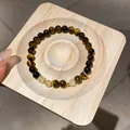 Detailed view of natural tiger eye and yellow crystal beaded bracelet on a wood stand - Style 76 (Vintage Maillard) / Brown