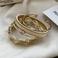 Set of four elegant gold-toned metallic bangles featuring irregular and textured designs - #1 Bracelet - Gold (four-piece Set)