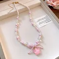 Close-up detail of the pink and white pearl necklace featuring a bow and resin star pendant - Necklace / Pink