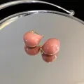 Close-up detail of high-quality gold-plated pink enamel bean-shaped earrings on a mirror - Retro Bean Style (2#)