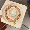 Elegant amber tiger eye stone bead bracelet with pink flower and gold bell charm detail - Style 72 (Gold Bell) / Yellow and Pink