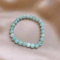 Elegant light blue round beaded stone bracelet displayed on champagne silk fabric - Style 85 / Diameter 6mm / Blue