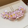 Nahaufnahme einer Haarspange aus rosa Stoffblumen mit goldenen Nadeln auf beigem Tablett - Haarstab / Rosa