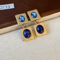 Vue détaillée de boucles d'oreilles carrées vintage dorées avec incrustations bleues. - Boucles d'Oreilles (Or-Bleu)
