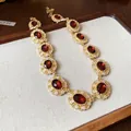 Collar vintage dorado con piedras preciosas rojas ovales y detalles florales blancos - Collar (78#) / Dorado/Rojo