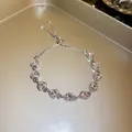 Detailopname van een roze hartvormige kristallen armband op een gouden presentatieblad - Strass Hart Stijl / Roze (Zilveren basis)