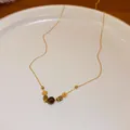 Detailansicht einer Retro-Tigerauge-Halskette mit goldenen floralen Schmuckperlen - 9# Halskette-Stil 3