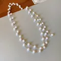 Detail of elegant French-style long necklace with faux pearls and gold chain. - Gold-White