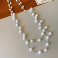 Close-up of elegant French long necklace with white pearls and silver chain. - Silver-White