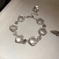 Nahaufnahme eines Glasperlenarmbands mit silbernen Schneeflocken auf einem Display - Schneeflocken-Stil (HB4991) / Silber