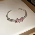 Detalle de un brazalete abierto de doble capa con un motivo de mariposa de circón rosa. - Mariposa-Rosa / Plateado