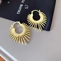 Nahaufnahme goldener Creolen im Sonnenstrahl-Design mit strukturierter Feuerwerk-Optik - Gold